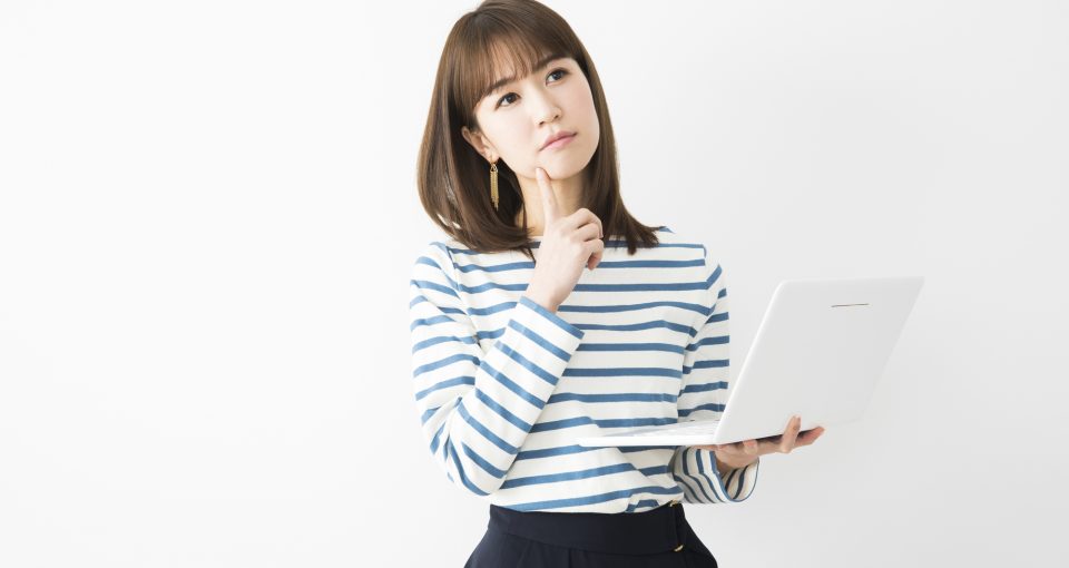 PCを見ながら考える女性